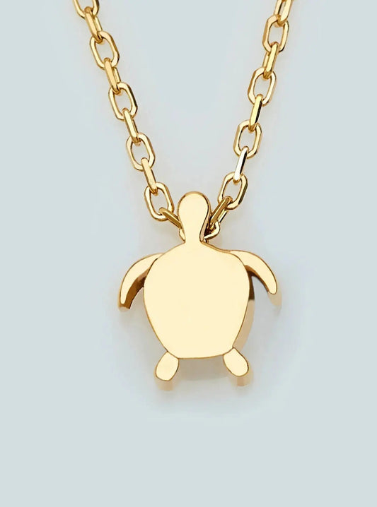 Gold-toned sea turtle pendant on a chain in a 14K Gold Tiny Turtle Necklace