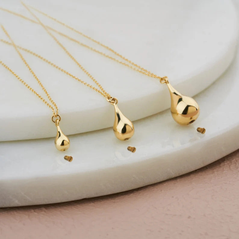 Three gold tear drop pendants on delicate chains featured in a 14K Gold Tear Drop Urn Necklace
