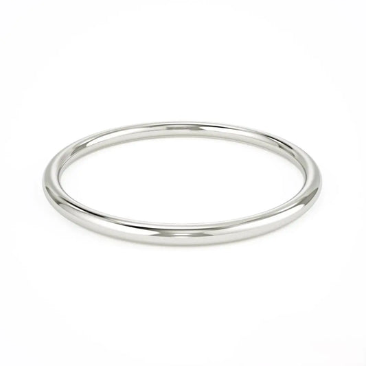 Simple silver bangle bracelet with a smooth surface beside an Elegant 14k Gold Wedding Band