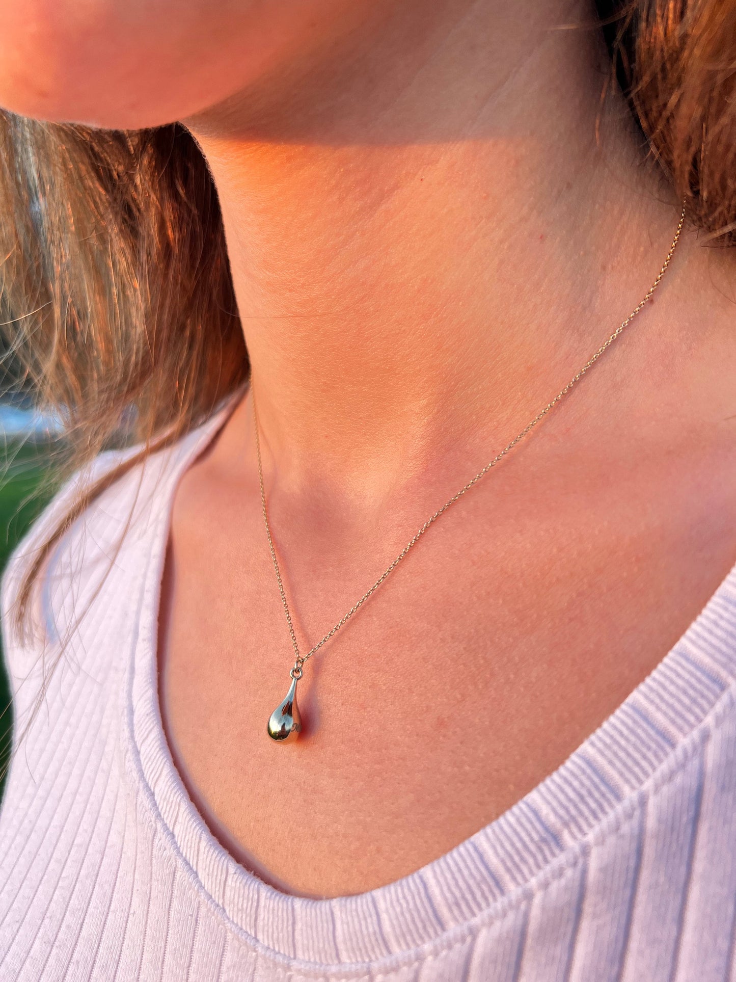 Delicate silver teardrop pendant on a personalized cremation urn necklace for keepsake