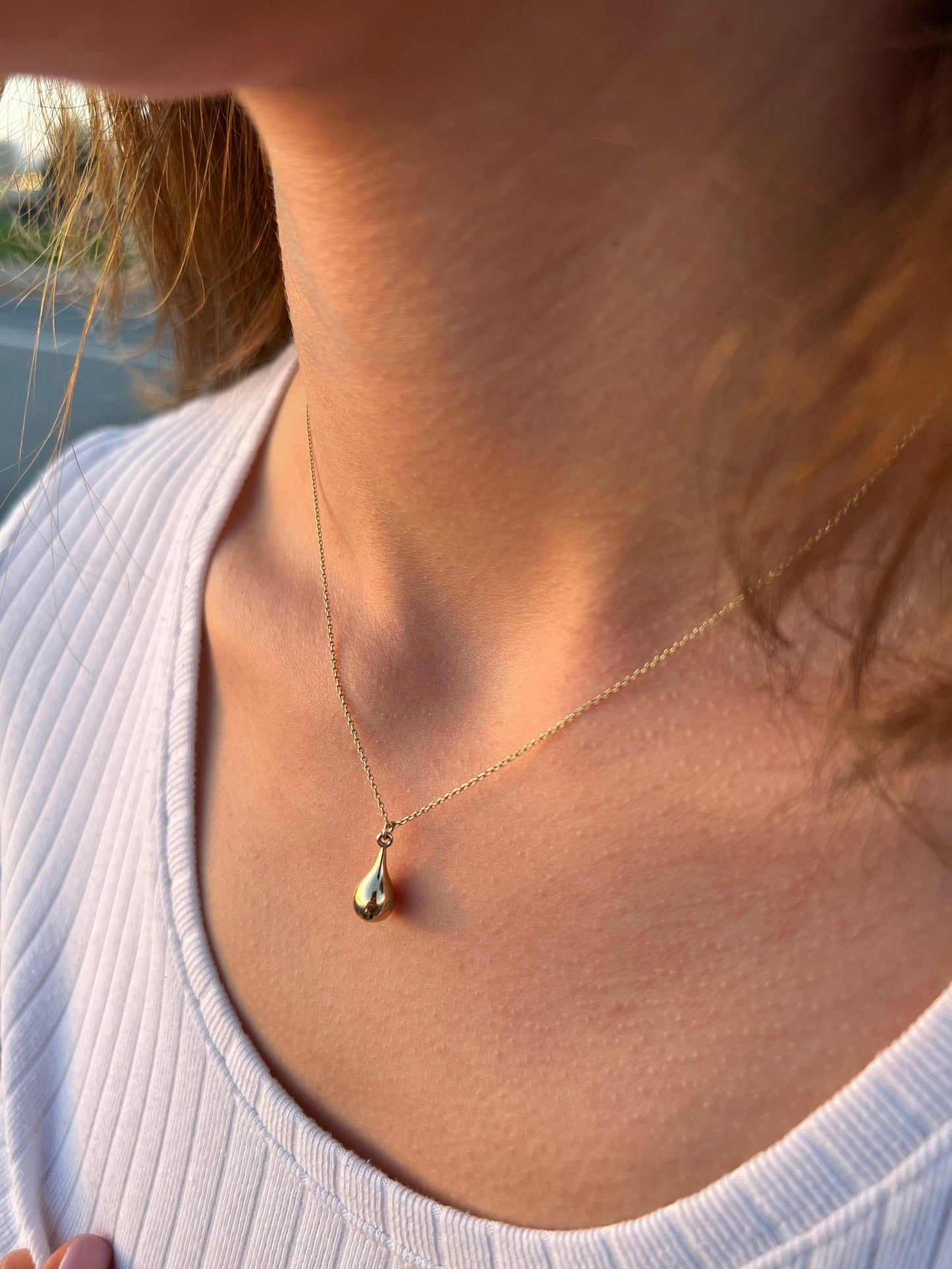 Delicate gold tear drop pendant on personalized cremation urn necklace for cherished memories