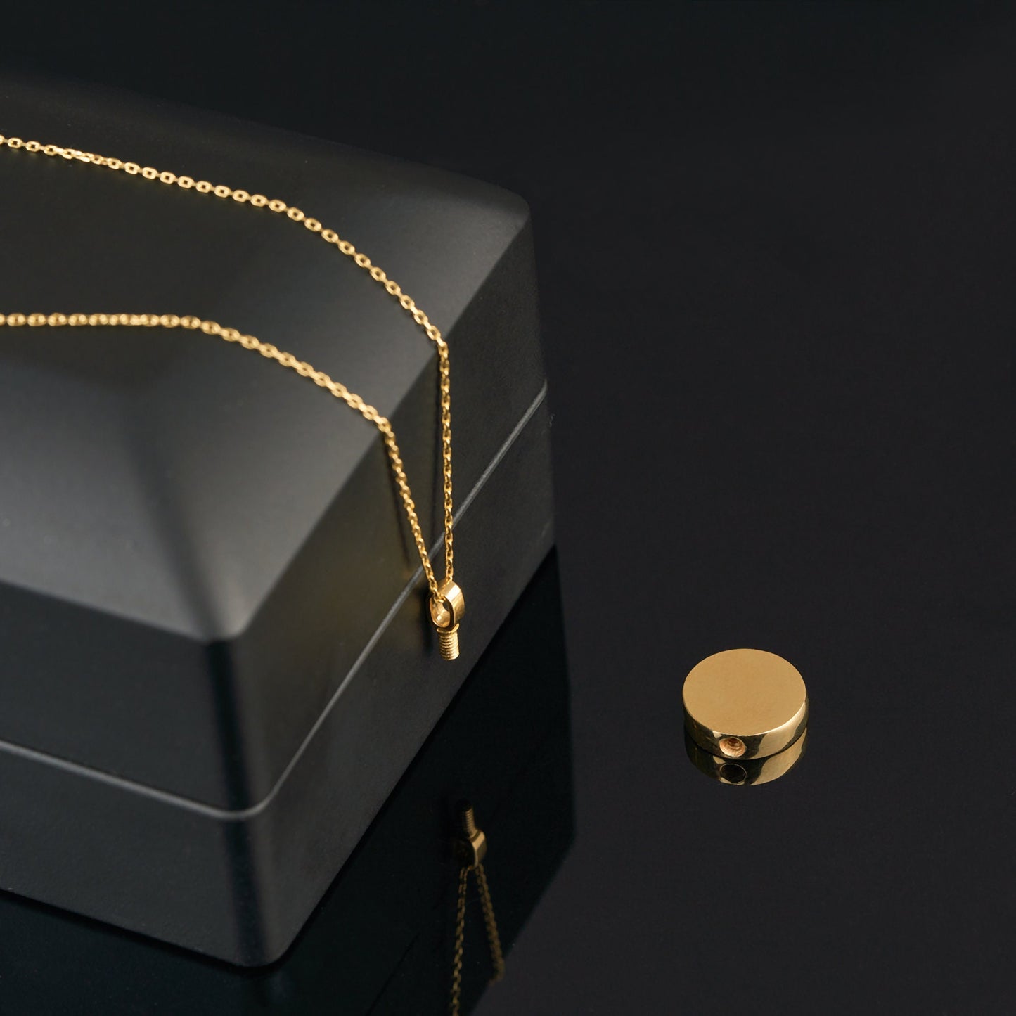 Gold cremation urn necklace featuring a personalized 14K solid gold pendant on dark surface