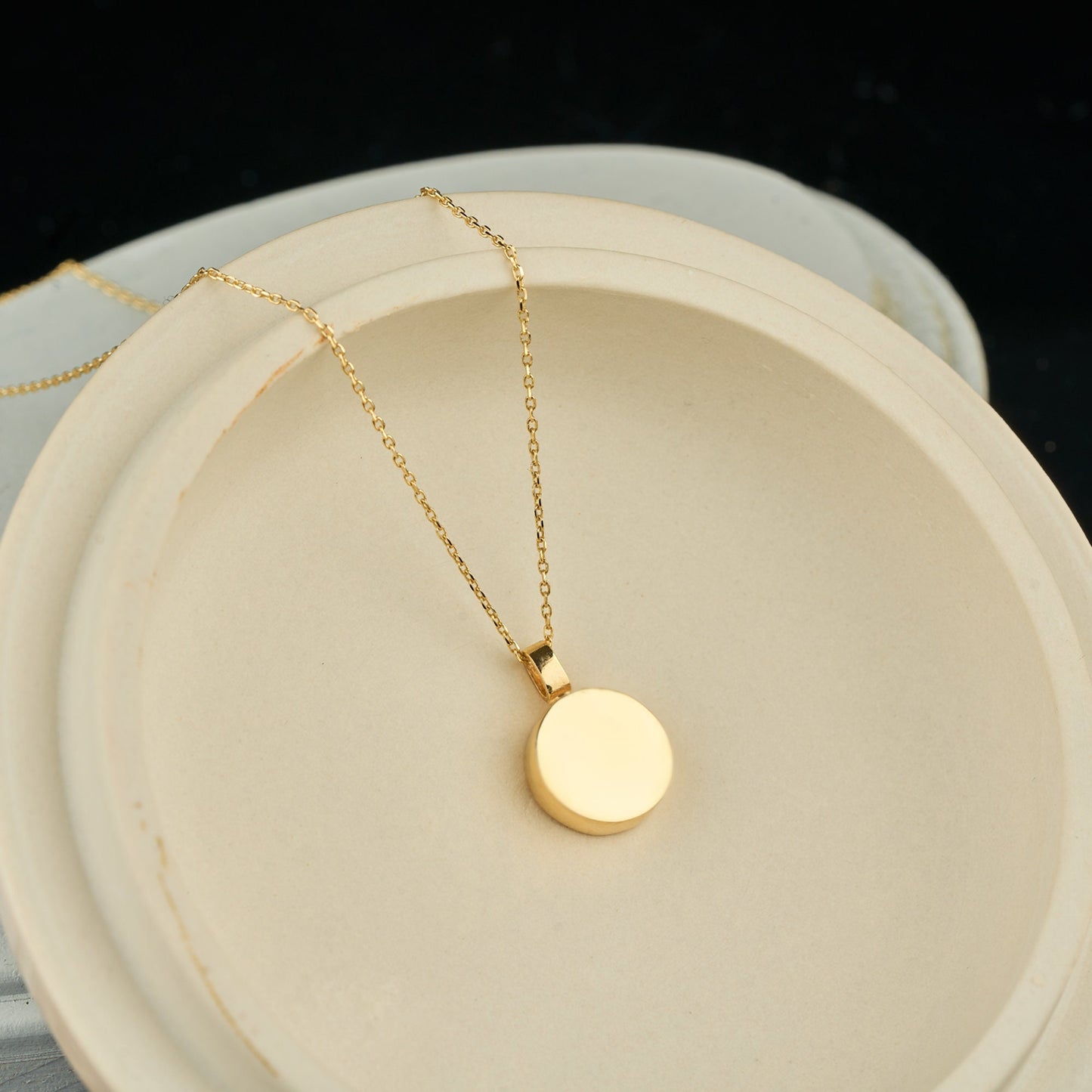 Gold circular pendant on a delicate chain necklace for a solid gold urn necklace