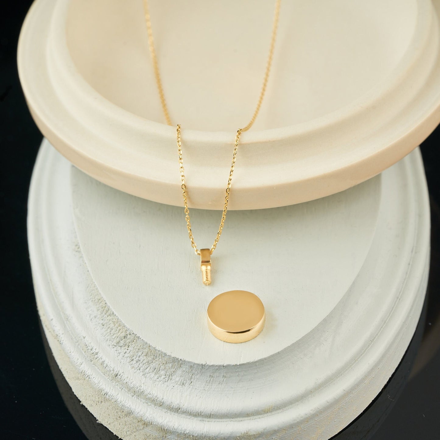 Gold circular pendant on delicate chain, a personalized solid gold urn necklace