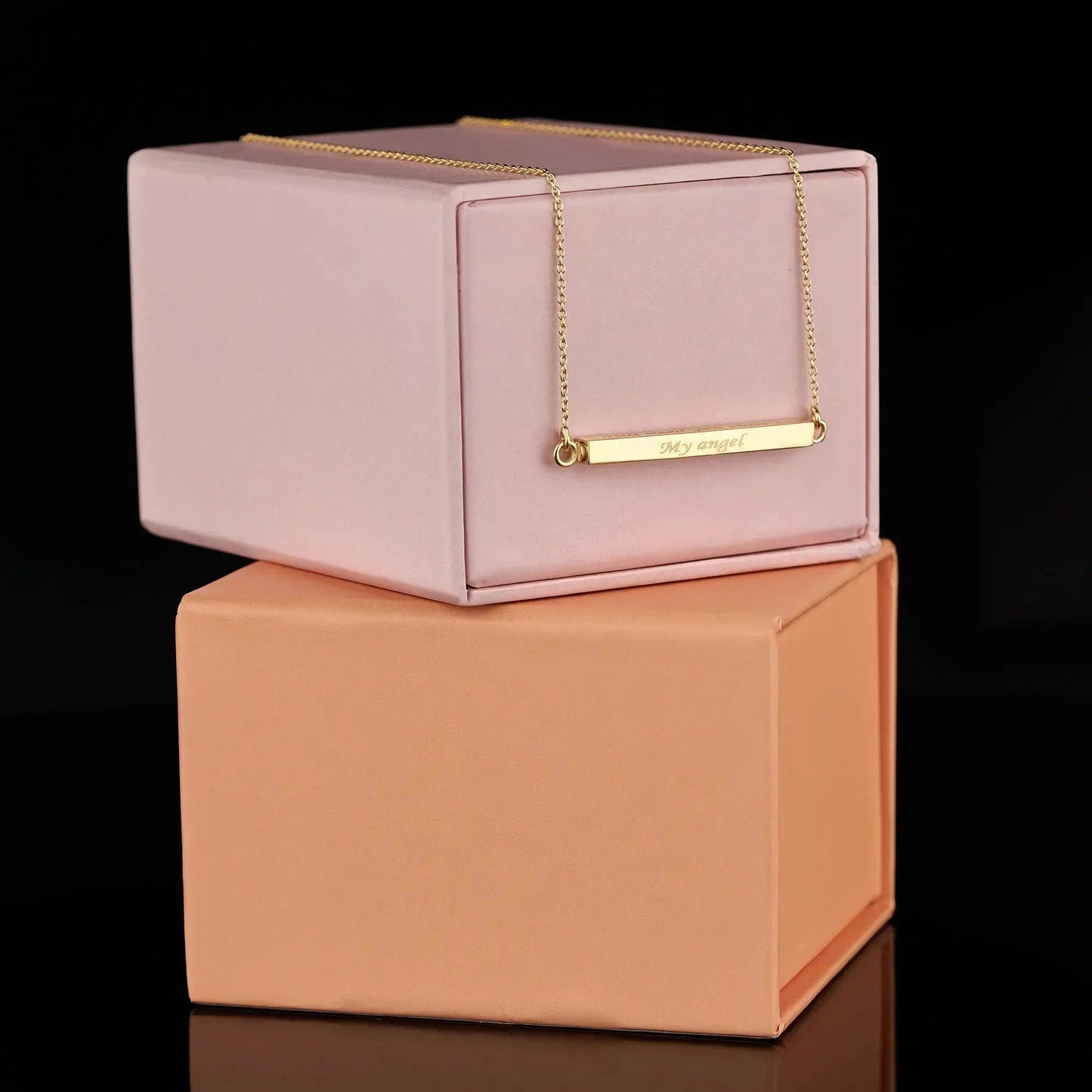 Gold bar necklace on pink and peach boxes for personalization cremation urn jewelry