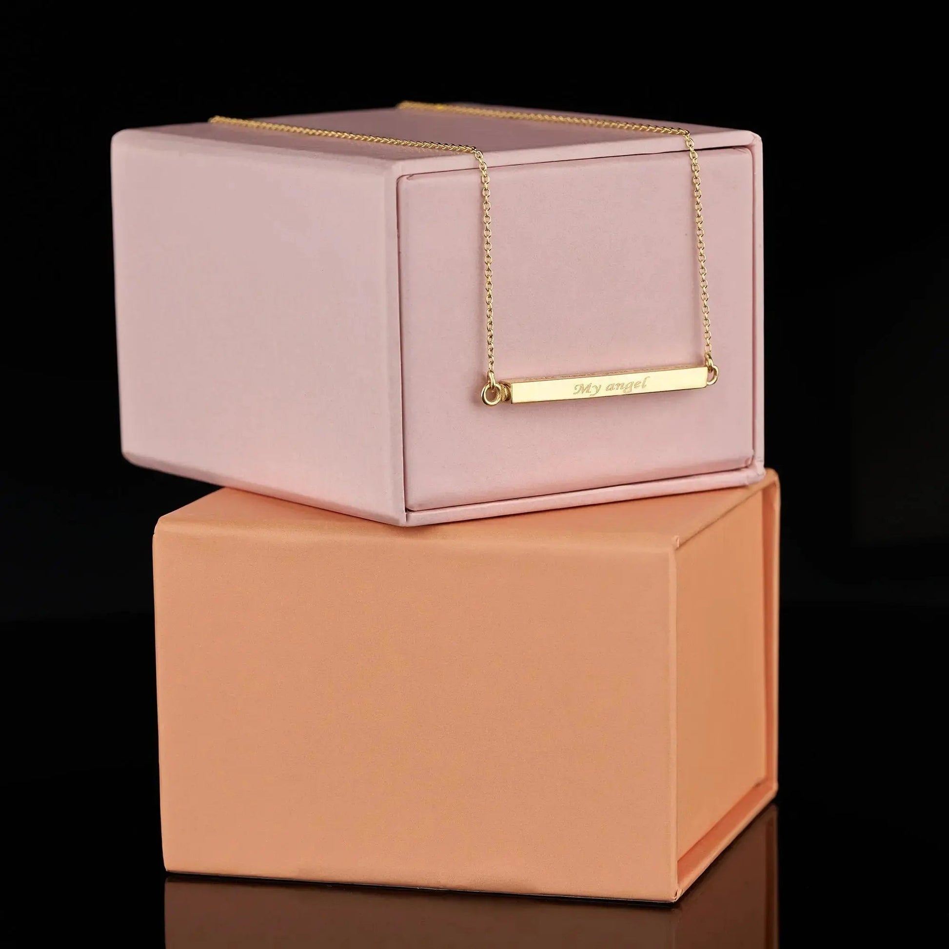 Gold bar necklace on pink and peach boxes for personalization cremation urn jewelry