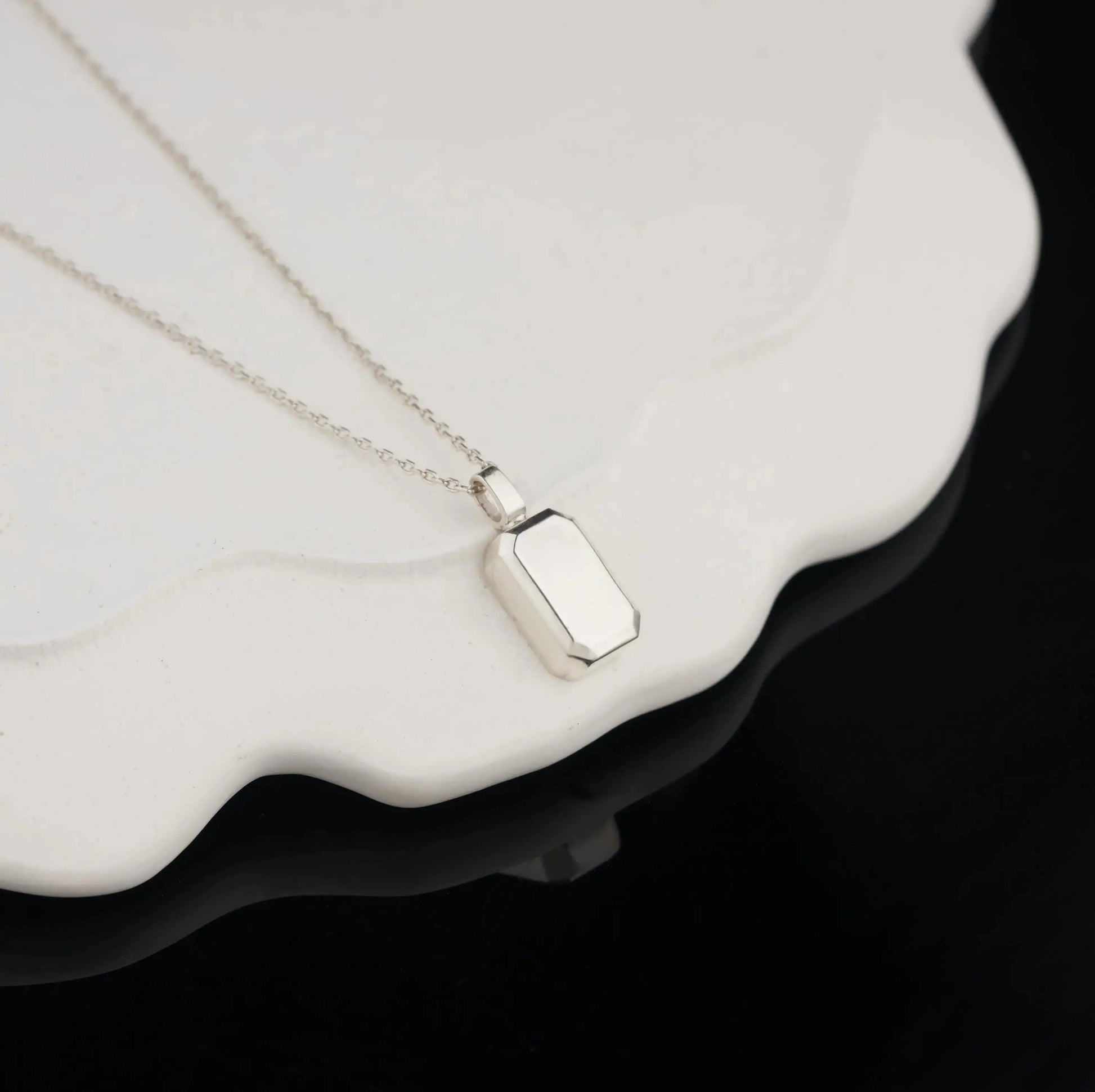 Sterling silver urn necklace featuring a rectangular charm on a delicate chain