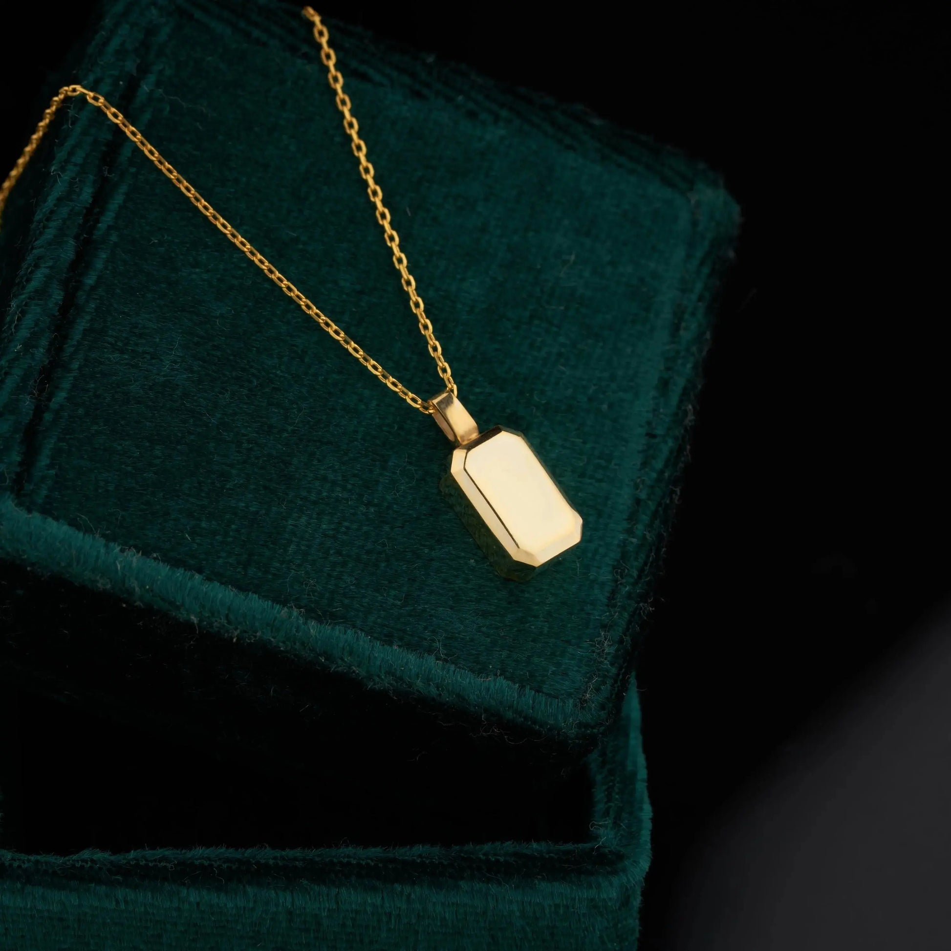 Gold plated urn necklace featuring a rectangular charm on a sterling silver chain