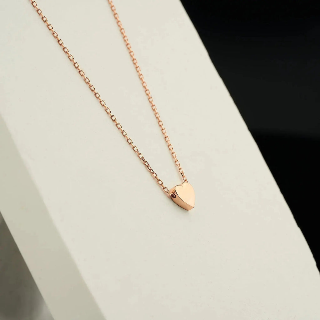 Delicate rose gold heart necklace featuring a solid gold heart pendant and engraving