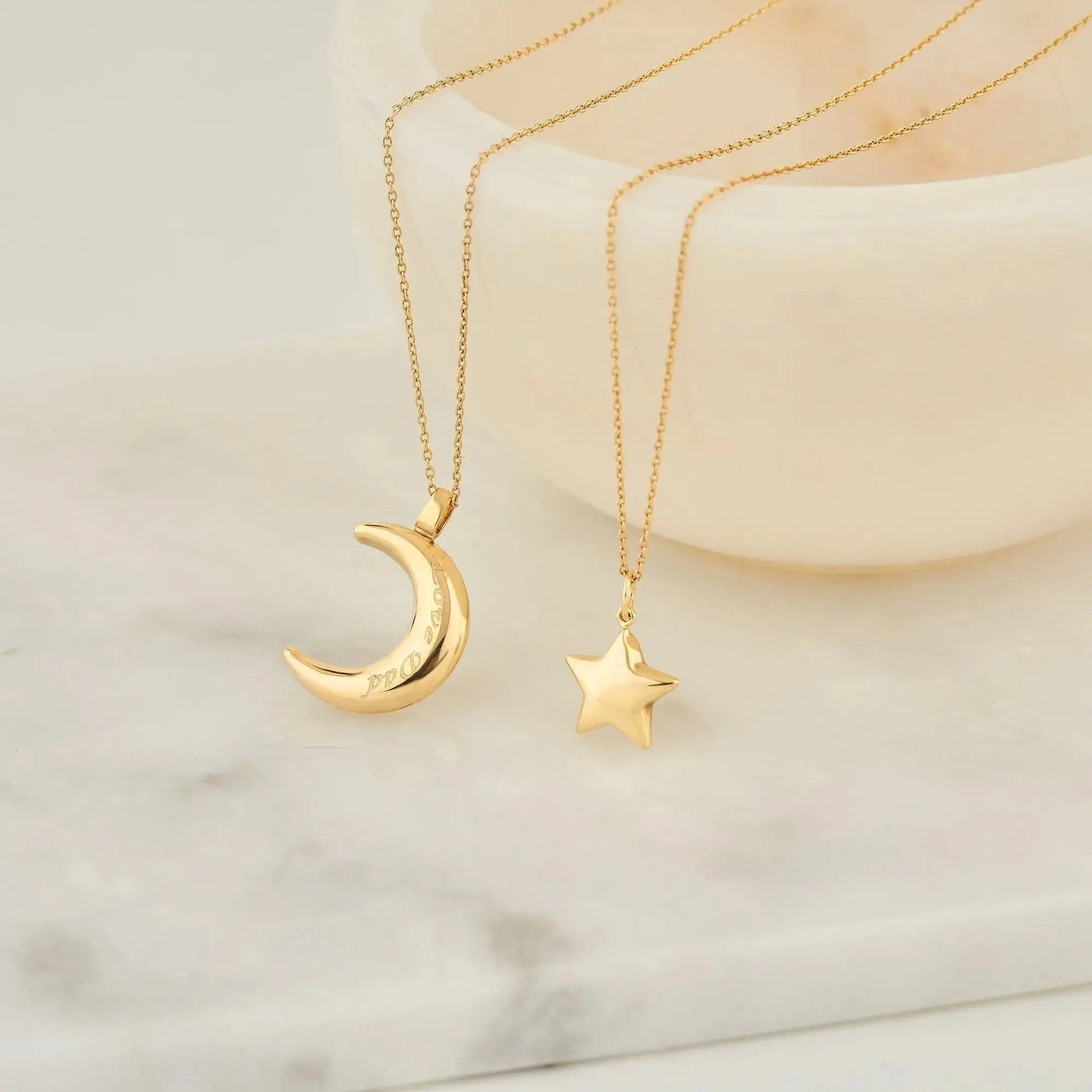 Two gold necklaces with crescent moon and star pendants, featuring 14K solid gold design