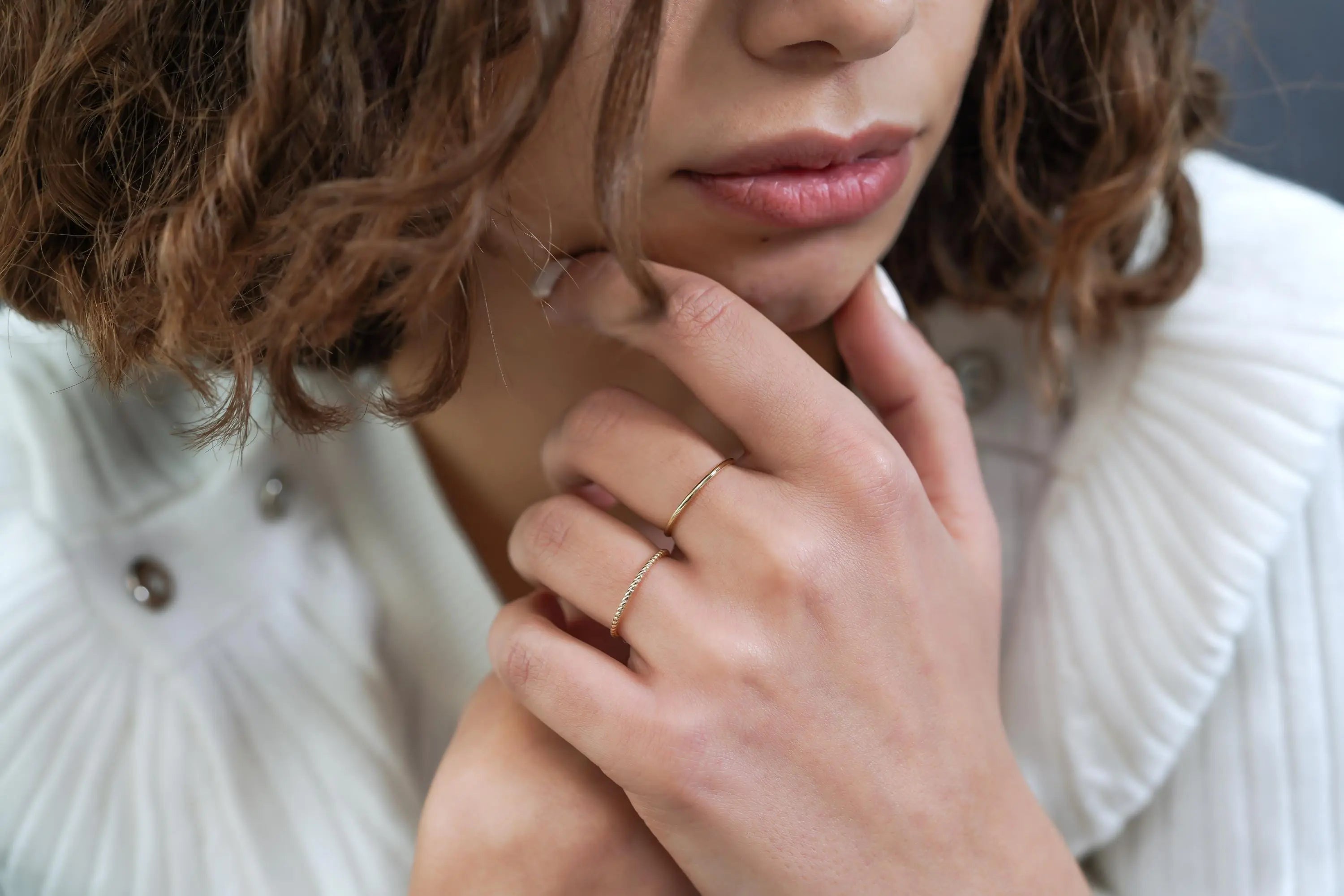 Elegant 14k Gold Wedding Band showcased on slender fingers with delicate gold rings