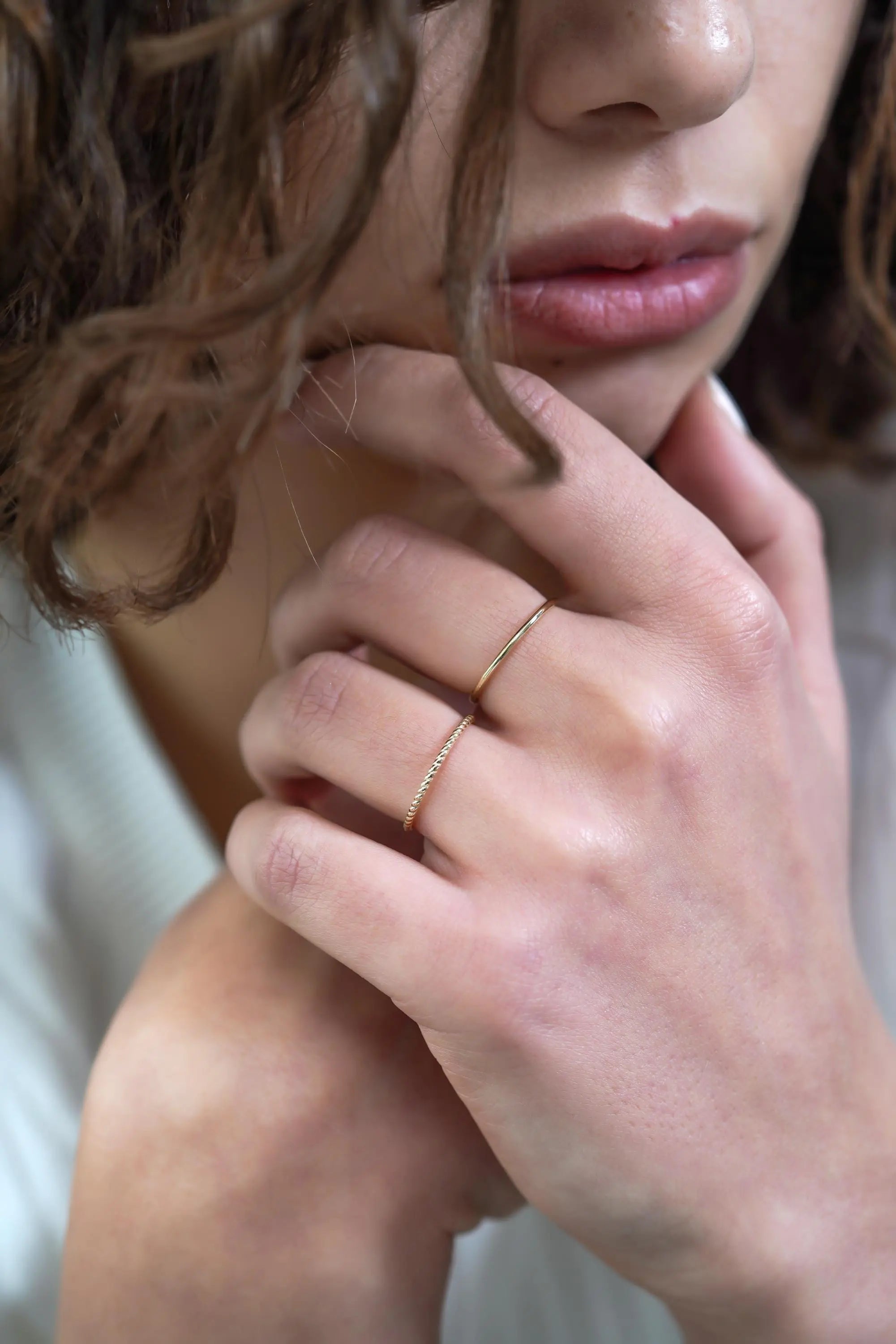 Delicate gold rings complementing pink-tinted lips with Elegant 14k Gold Wedding Band