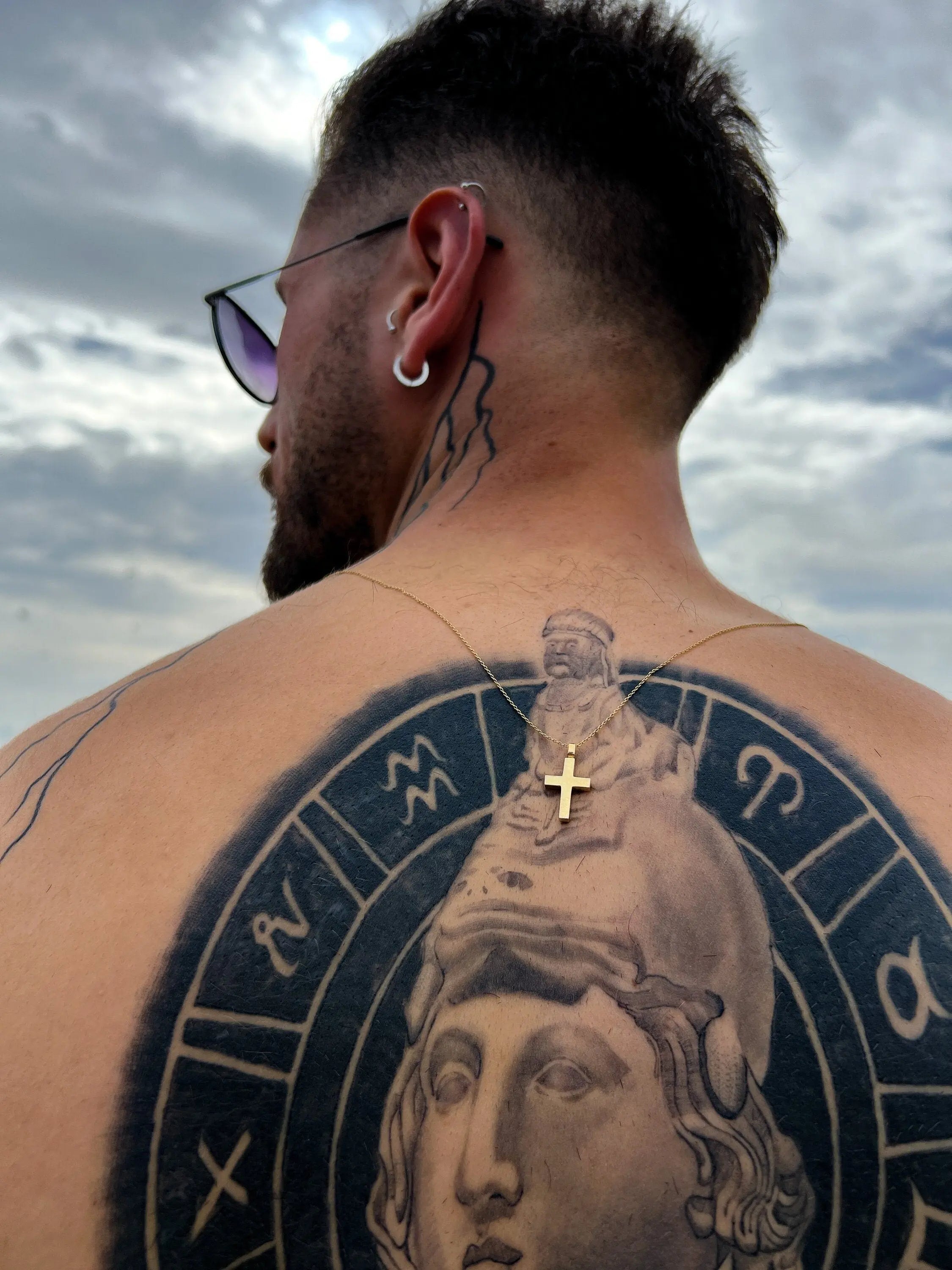 Back tattoo of a classical statue head with zodiac symbols, enhancing Sterling Silver Urn Necklace