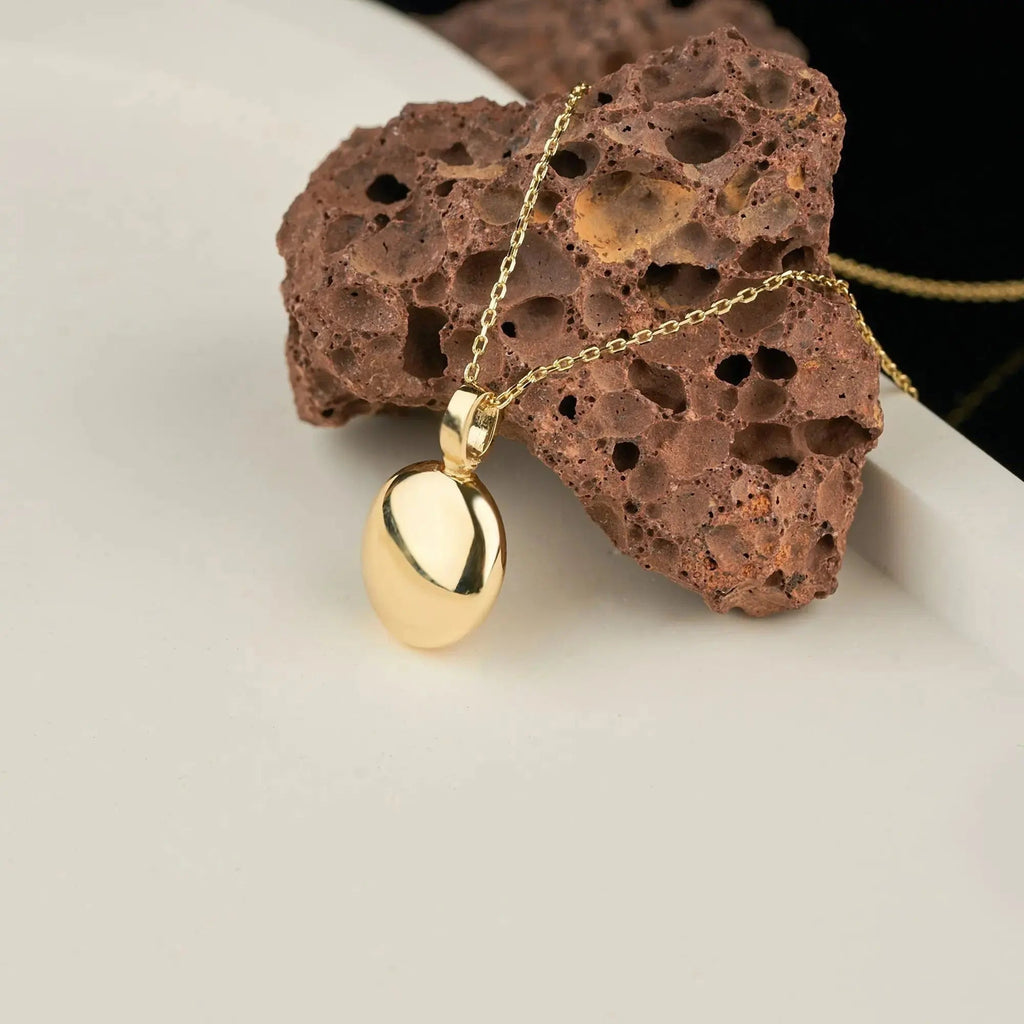 Gold pendant necklace with teardrop charm, part of Ash Holder Round Urn design