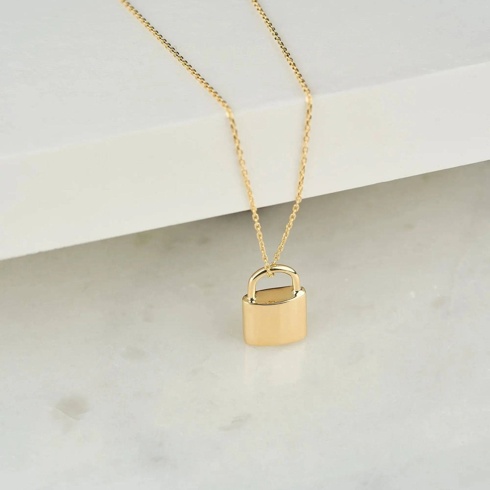 Gold padlock urn necklace on a delicate chain for memorializing loved ones and pets