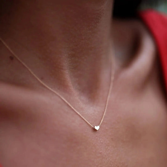 Delicate gold necklace featuring a solid gold heart pendant, perfect for bridesmaid gifts